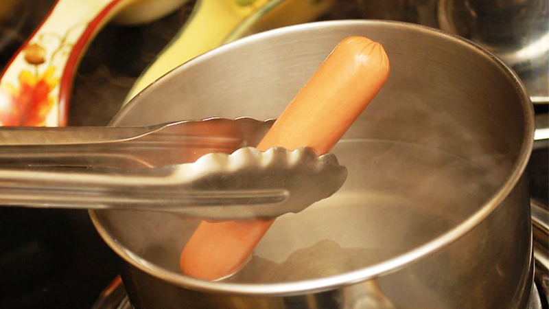 chần xúc xích trong nước sôi khoảng 8 phút